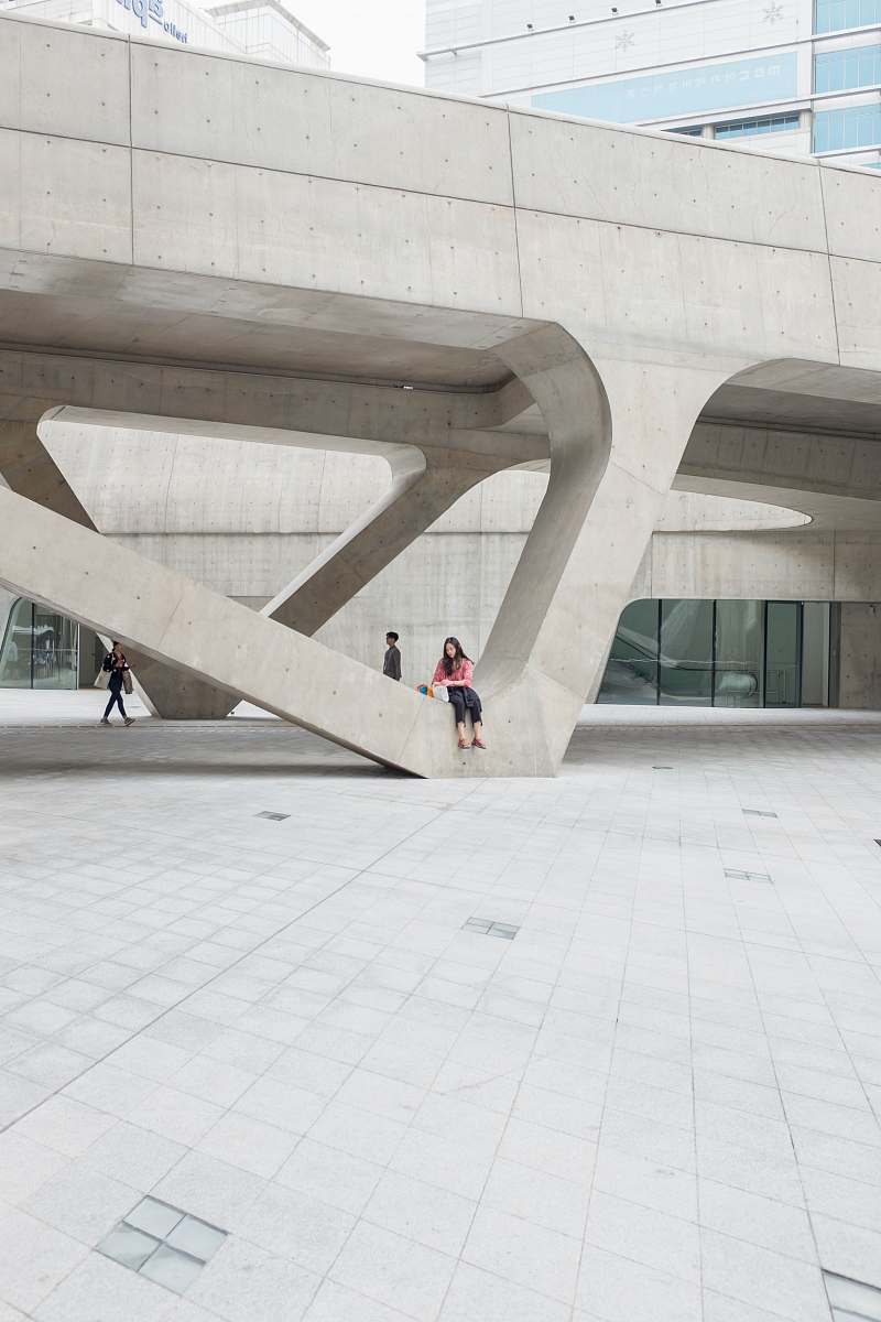 dongdaemun design plaza woman sitting on gray concrete formation during daytime south korea